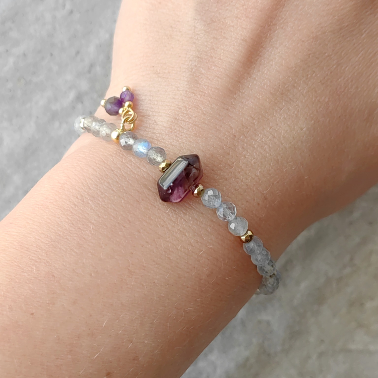 Bransoletka zodiakalna Strzelec z granatem, labradorytem i kryształem górskim na nadgarstku — biżuteria Twin Flames Jewellery