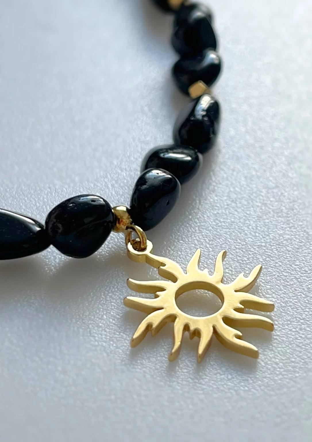 Elegancki naszyjnik z czarnych kamieni ze złotą zawieszką słońca — biżuteria Twin Flames Jewellery